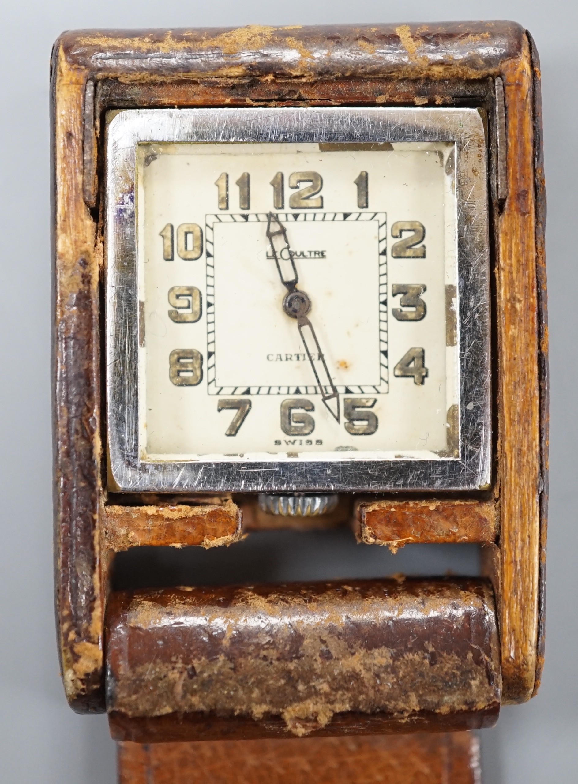 A mid 20th century leather case mounted stainless steel LeCoultre for Cartier travelling watch, with Arabic dial, 5cm.